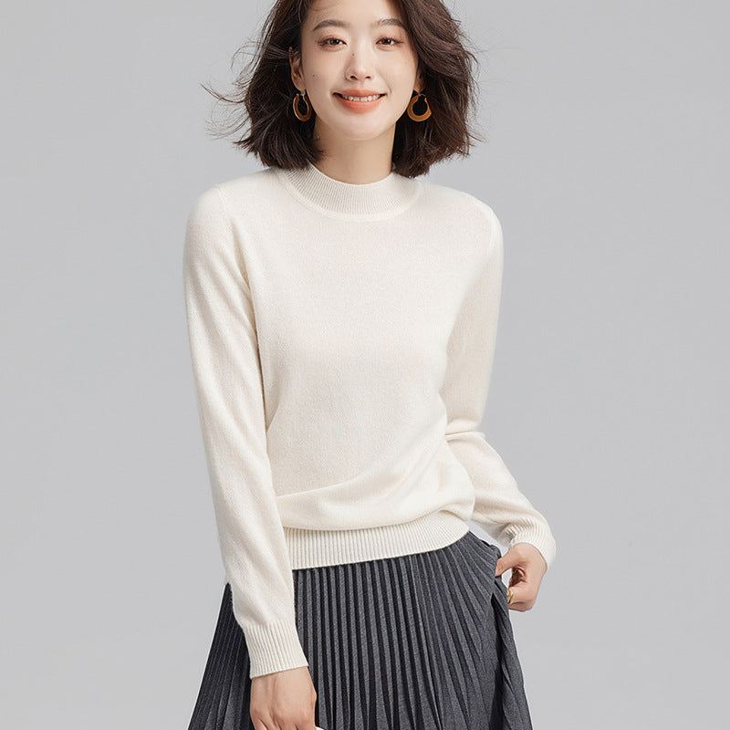 Pull femme 100 % cachemire à col cheminée, coloris écru, porté avec une jupe plissée