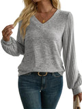 Pull col V femme gris chiné à manches côtelées bouffantes, porté avec un jean, vue de face