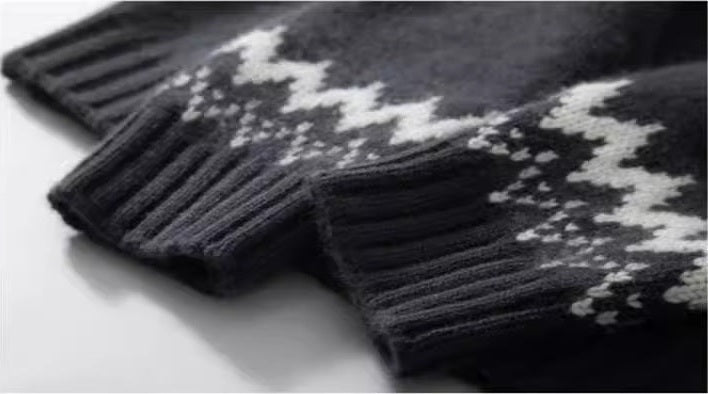 Gros plan du poignet côtelé et du motif jacquard sur la manche (coloris gris carbone)