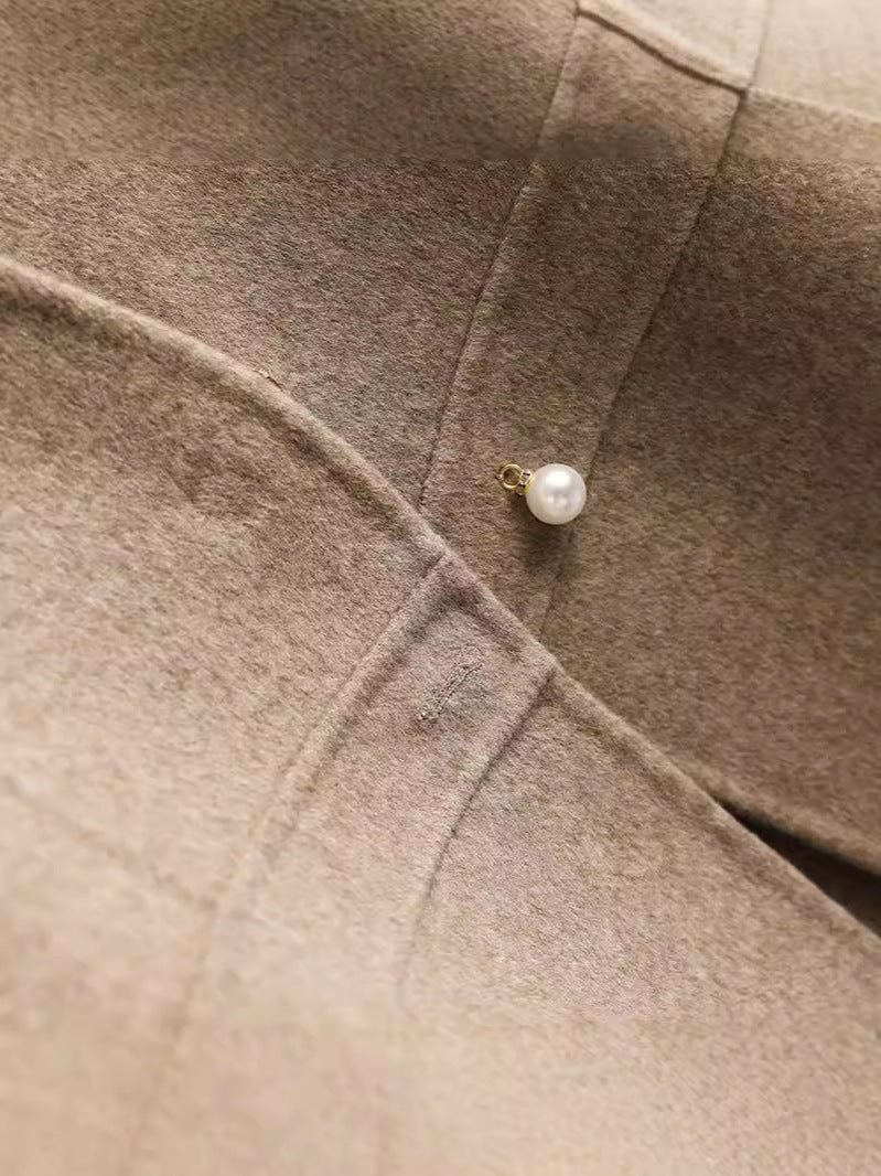 Détail du bouton perlé et de la maille de laine du gilet cache-cœur