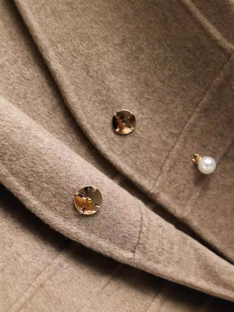Détail des boutons dorés et de la finition du gilet cache-cœur en laine